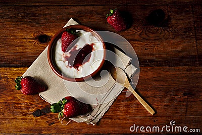 Plain yogurt with strawberry jam and strawberries, a delicious simple and healthy dessert from our Mediterranean diet Stock Photo