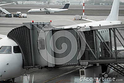 Plane on airport connected to gate sleeve. Aircraft and sleeve. Gate at the airport for passengers to plane boarding. Stock Photo