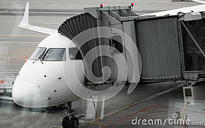 Plane on airport connected to gate sleeve. Aircraft and sleeve. Gate at the airport for passengers to plane boarding. Stock Photo