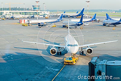 Plane on airport connected to gate sleeve. Aircraft and sleeve. Gate at the airport for passengers to plane Editorial Stock Photo