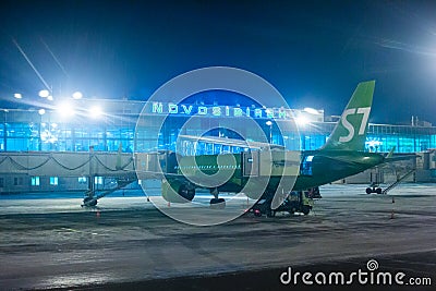 The plane at the airport disembarks passengers through the sleeve Editorial Stock Photo