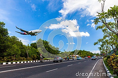 Plane danger landing near road on the tropical island Bali, Ngurah Rai Airport, Tuban, Badung Regency, Bali, Indonesia Editorial Stock Photo