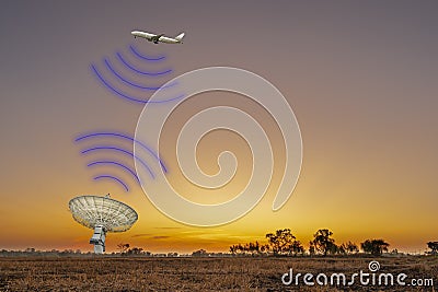 The plane flew in the sky communicating with the satellite station or radar on ground as the sun rises in the morning Stock Photo