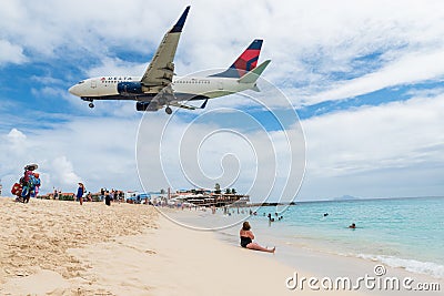 Plane landing flying over famous Maho Beach Editorial Stock Photo