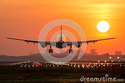 Plane is landing during sunrise. Stock Photo