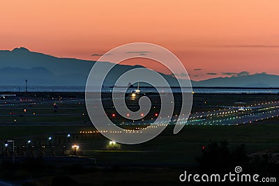 The plane makes landing on the runway at night Stock Photo