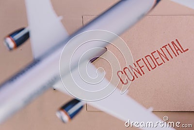 The Plane Model Over The Confidential Brown Envelop Stock Photo