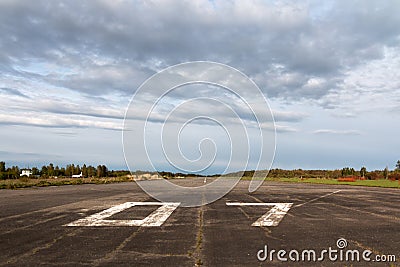 Plane runway, airstrip in the airport terminal with marking on blue sky with clouds to use as background. Travel Stock Photo