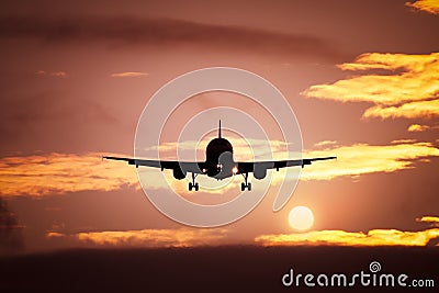 Plane in the sunset sky Stock Photo