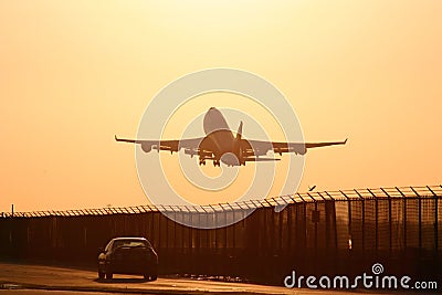 Plane Taking Off into Sunset Stock Photo