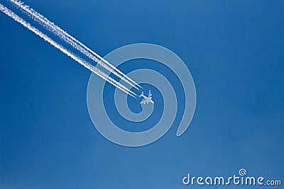 Plane with vapor trails in a blue sky Editorial Stock Photo