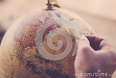 Planet earth on sphere with hand and little paper boat for travel and dream concept - move around the world with cruise ship and Stock Photo