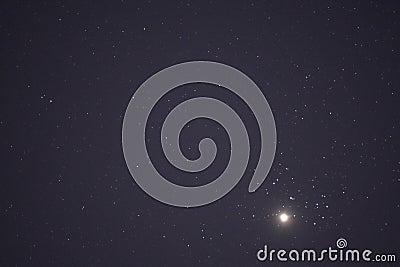 The planet Venus in the starry night sky in conjunction with the Pleiades Constellation Stock Photo