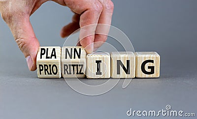 Planning and prioritizing symbol. Concept words Planning and Prioritizing on wooden cubes. Businessman hand. Beautiful grey Stock Photo