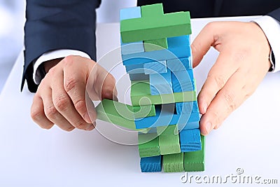 Planning, risk and strategy in business, businessman getting out a wooden block from a tower Stock Photo