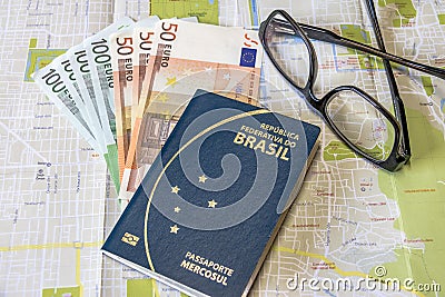 Planning a trip - Brazilian passport on city map with euro bills money and glasses Stock Photo