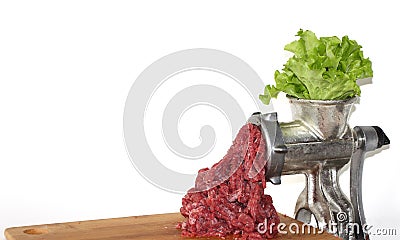 Leaves of salad in meat grinder. ground beef comes out of the meat grinder. Plant-based meat concept. Stock Photo