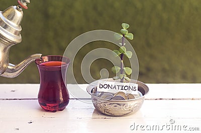 Plant growing out of algeria coins in silver bowl ,money saving for donations and drinking an arabic tea. Stock Photo