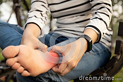 Plantar fasciitis,asian young woman holding her feet and massage with her hand suffer from tendon inflammation,female people sore Stock Photo