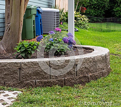 Planting bed surrounded by block retaining wall Stock Photo