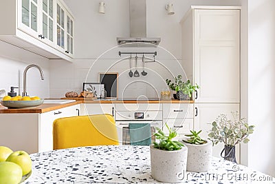 Table in stylish white kitchen interior, real photo Stock Photo