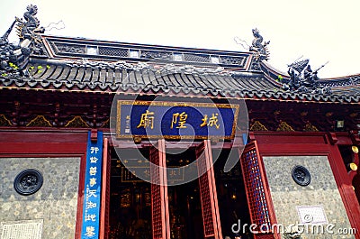 The plaque of the City God Temple has golden letters and borders, black tiles, a dragon head carved on the roof, a red-lacquered Editorial Stock Photo