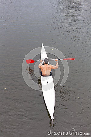 PLASENCIA, SPAIN - Aug 11, 2020: Plasencia, Caceres, Spain - August 11, 2020: A muscular young man paddles his canoe Editorial Stock Photo