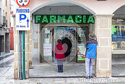 PLASENCIA, SPAIN - DECEMBER 07, 2020: Queue of people waiting to access the interior of the pharmacy Editorial Stock Photo
