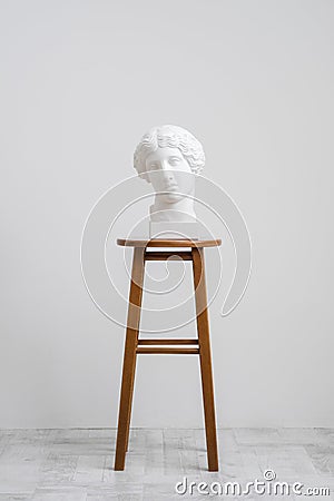 Plaster head, antique sculpture for learning to draw. Standing on a stool on a white background. Stock Photo