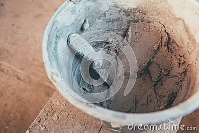 Plaster inside bucket with putty knive for wall renovation Stock Photo