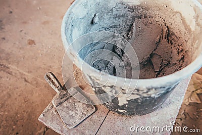 Plaster inside bucket with putty knive for wall renovation Stock Photo