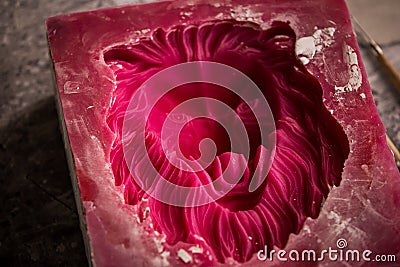 Plaster workshop. Separates the silicone mold from the plaster sculpture of the lion`s head. Stock Photo