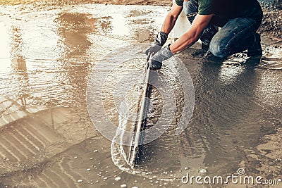 Plasterer concrete worker at floor of house construction Stock Photo