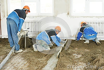 Plasterer concrete worker at floor work Stock Photo