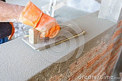 Plasterer concrete worker at wall of house construction Stock Photo