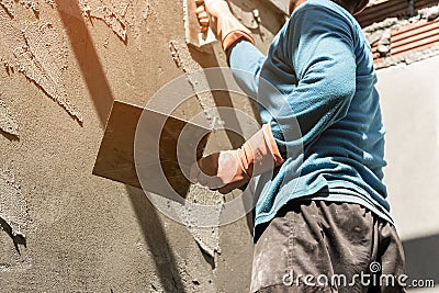 Plasterer concrete worker at wall of house Stock Photo