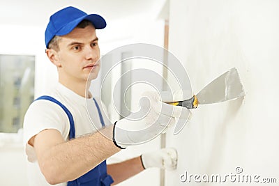 Plasterer with putty knife at wall filling Stock Photo