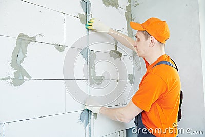 Plasterer installing screed on wall for plastering Stock Photo