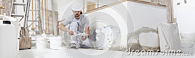 Plasterer man at work, take the mortar from the bucket with trowel to plastering the wall of interior construction house site and Stock Photo