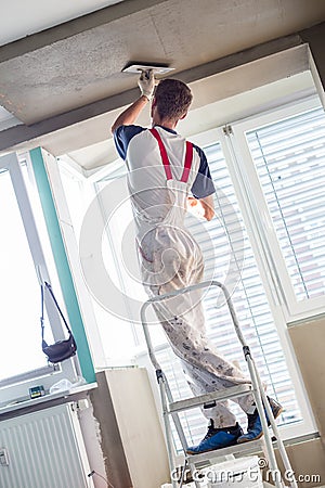 Plasterer renovating indoor walls and ceilings. Finishing works. Stock Photo