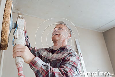 Plasterer smoothing interior wall with machine Stock Photo