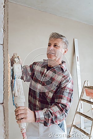 Plasterer smoothing interior wall with machine Stock Photo