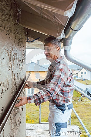 Plasterer smoothing plaster on a facade Stock Photo