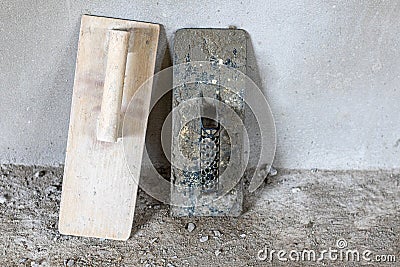 Plastering trowel leaning on gray cement walls. Stock Photo