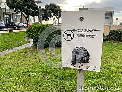 Plastic bag dispenser for collecting pet dog poop or excrement from the ground Editorial Stock Photo