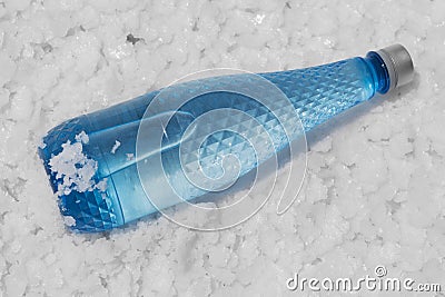 Plastic bottle full of water, lies on plates of natural salt, concept Stock Photo