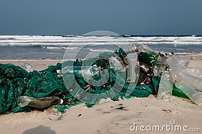 Old fishing net thrown to the seashore. trash on the sea beach. ecological problem. Environmental pollution Stock Photo