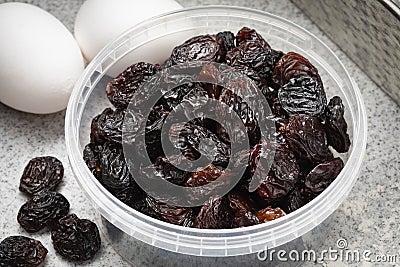 Plastic bowl with black flame raisins from Chili close up Stock Photo