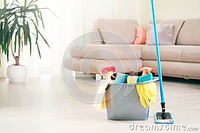 Plastic bucket with mop, sanitary items indoors.Room cleaning Stock Photo