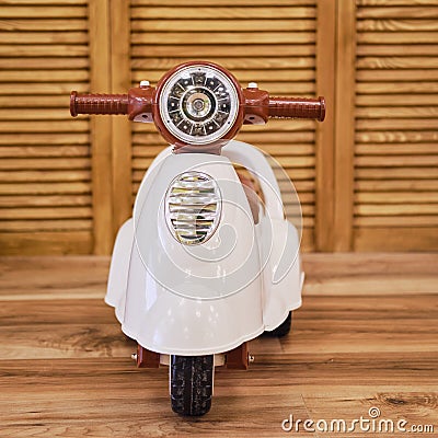 Plastic children motorcycle riding in the playroom, toy brown moped fo Stock Photo
